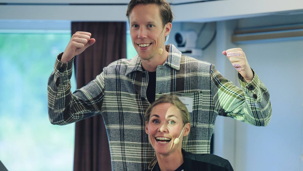 Två glada personer som poserar framför kameran.